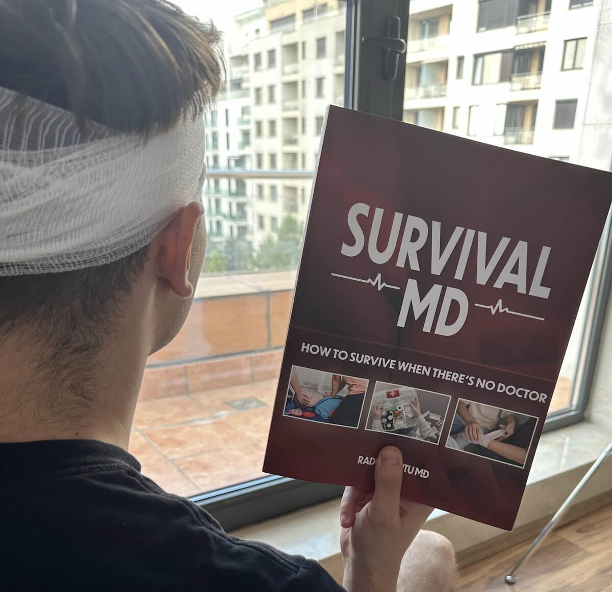 A man with a bandaged head reading Survival MD